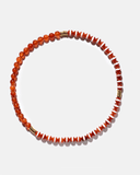Necklace with orange and white beads on a light gray background