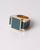 Gold ring with a green square stone on a light gray background