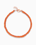 Orange and rose gold silk braided bracelet on a white background