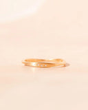 Gold ring with small diamonds on a beige background