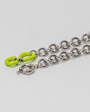 Silver chain necklace with a bright green clasp on a light gray background