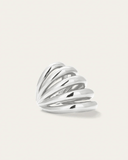 Silver ear cuff with wavy design on a light beige background