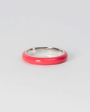 Silver ring with pink enamel band on a light gray background