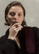 A woman showcasing a sculptural colorful ring