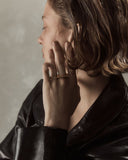 Woman wearing a gold ring with a neutral background