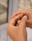 Hand holding gold rings with a blurred background