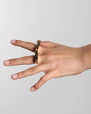 Two gold rings on a finger against a plain background
