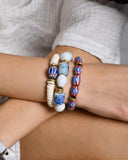 Two beaded bracelets on a wrist with a neutral background