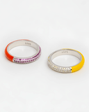 Two rings with colorful enamel bands and stones on a white background