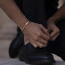 man wearing a gold stylish bangle. designer jewelry.