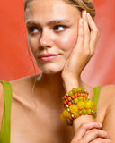 Woman wearing colorful beaded bracelets on a red background