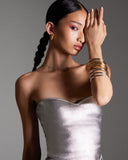 Woman wearing gold and silver bangles on a neutral background 2