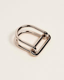 A polished silver metal ring with a double-loop design, shown on a clean, light beige background.